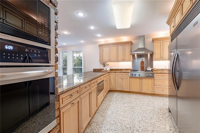 kitchen featuring wall chimney range hood, kitchen peninsula, light brown cabinetry, appliances with stainless steel finishes, and ornamental molding