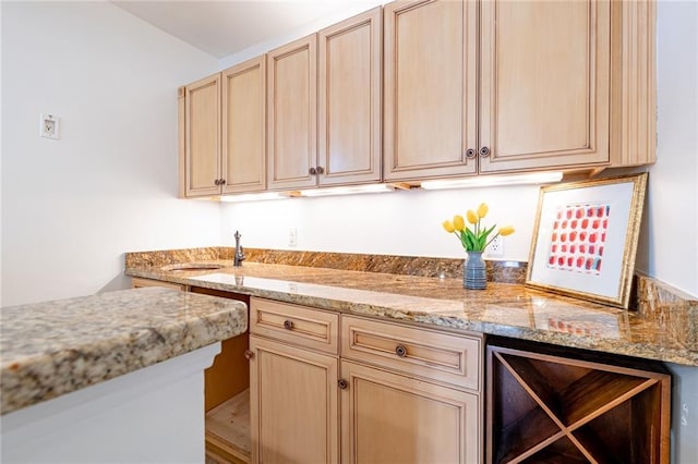 kitchen featuring light brown cabinetry, light stone countertops, sink, and beverage cooler