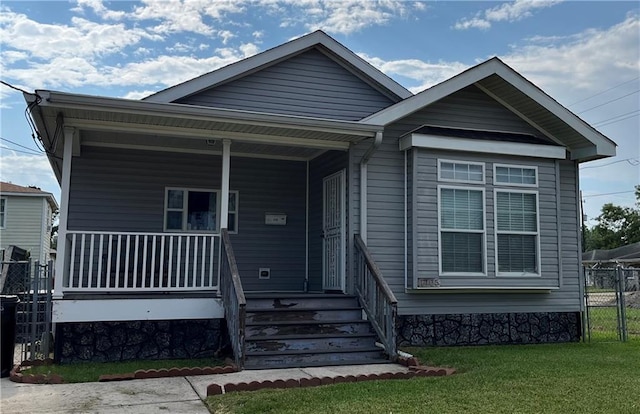 view of front of house with covered porch and a front lawn