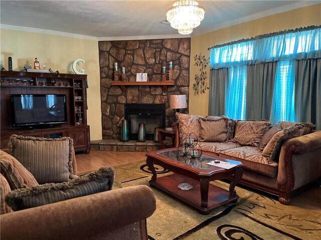 living room featuring ornamental molding, a chandelier, a stone fireplace, and wood-type flooring