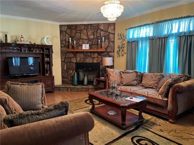 living room featuring ornamental molding, a notable chandelier, a fireplace, and wood finished floors