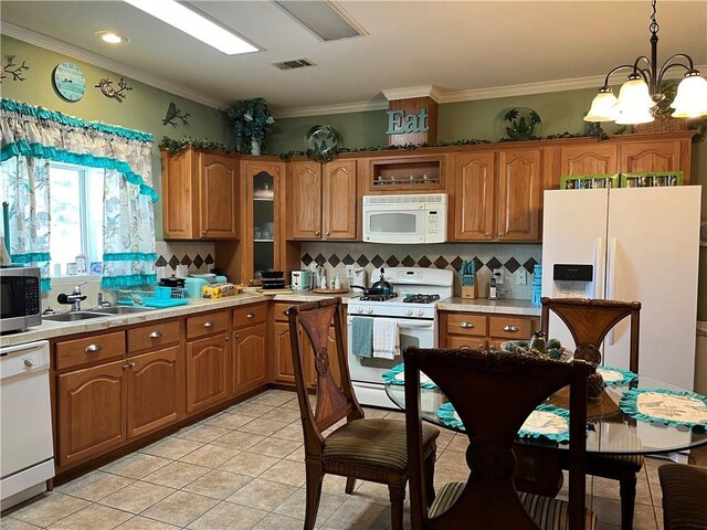 kitchen with backsplash, white appliances, a chandelier, light tile patterned floors, and hanging light fixtures