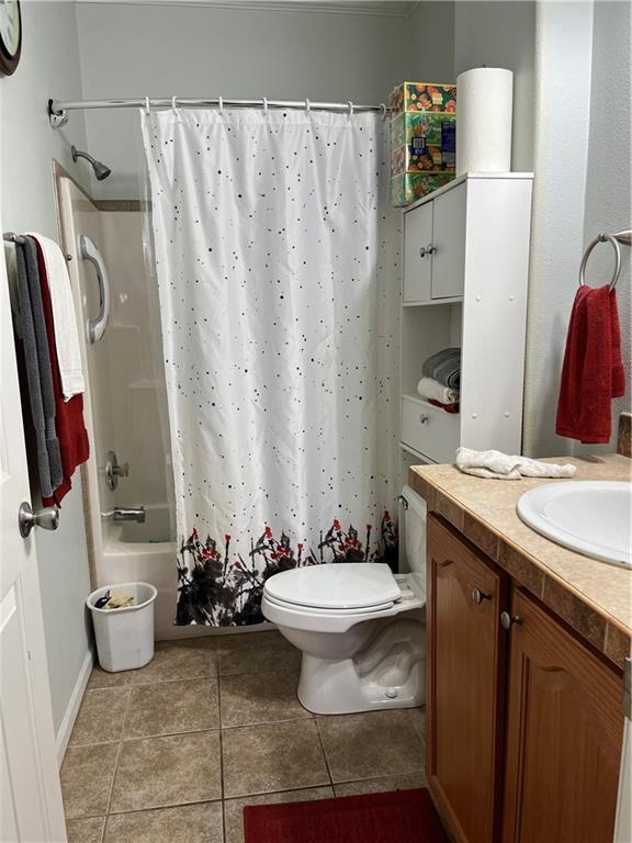 full bath with toilet, shower / bath combination with curtain, vanity, and tile patterned floors