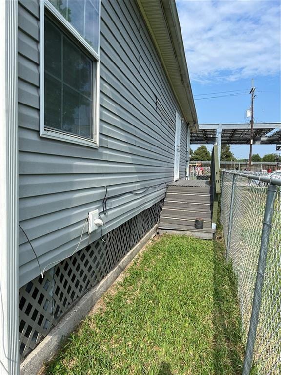 view of side of property with a yard, crawl space, and fence