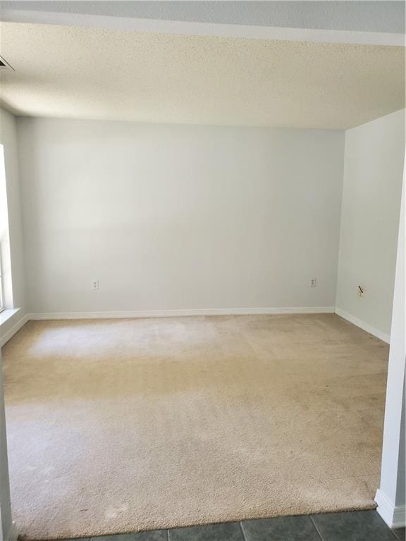 carpeted empty room with a textured ceiling