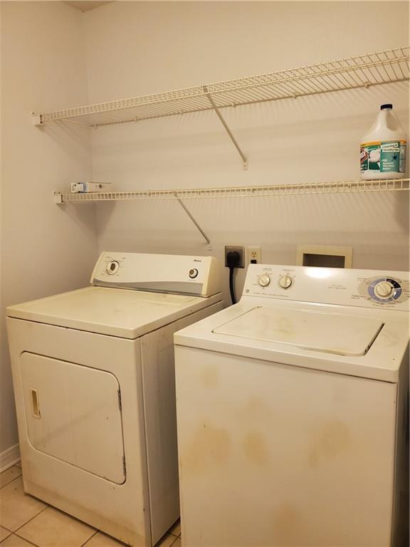 1122 Lori Dr, Slidell, LA 70461 - laundry room with washer and clothes dryer and light tile patterned flooring