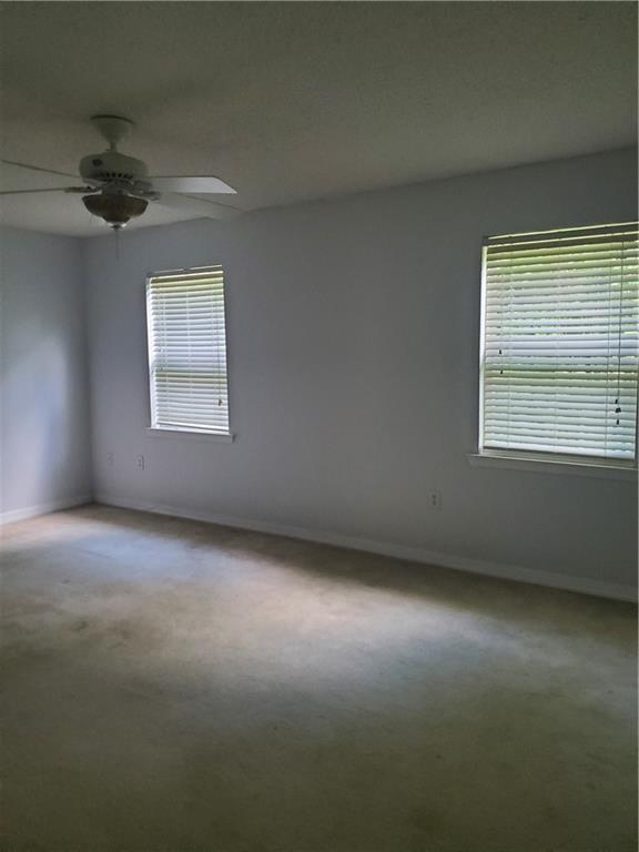 1122 Lori Dr, Slidell, LA 70461 - carpeted spare room with baseboards, healthy amount of natural light, and a ceiling fan