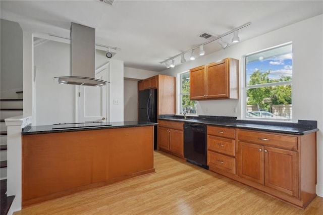 kitchen featuring sink, rail lighting, light hardwood / wood-style floors, island exhaust hood, and black appliances