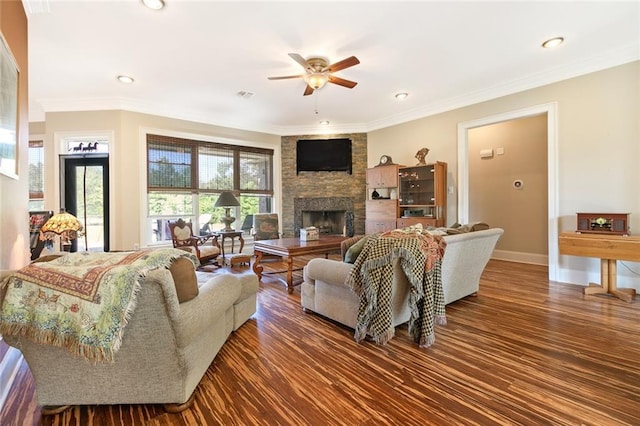 living room featuring crown molding, dark hardwood / wood-style floors, ceiling fan, and a fireplace