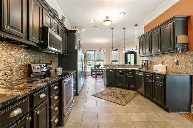 kitchen with light tile patterned floors, hanging light fixtures, stainless steel appliances, ornamental molding, and dark stone counters