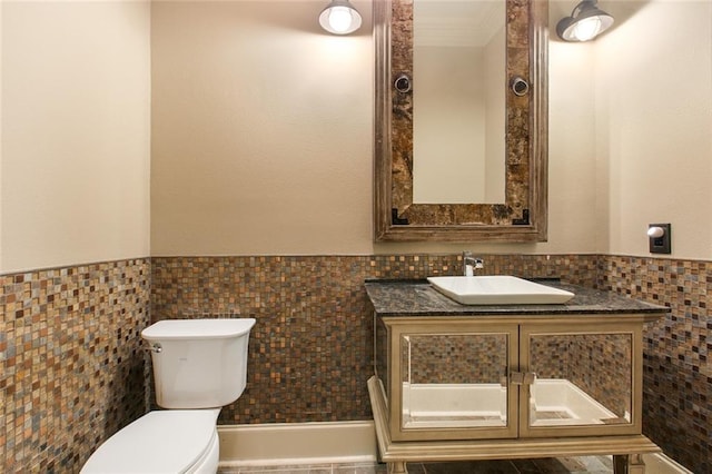 bathroom with tile walls, vanity, and toilet