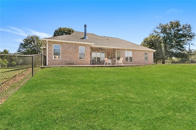 rear view of property featuring a lawn and a patio area