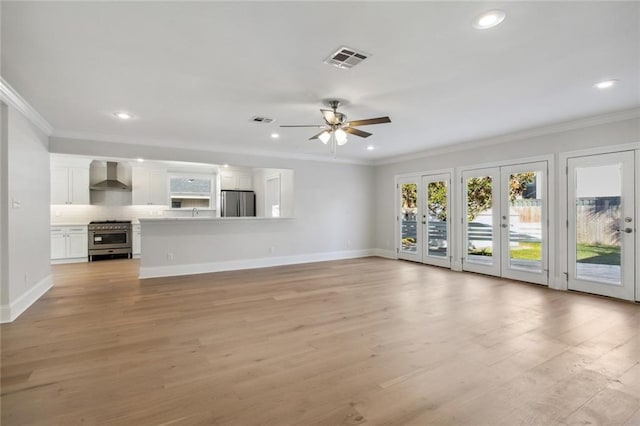 unfurnished living room with ornamental molding, light wood-type flooring, and visible vents