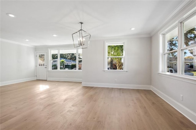 unfurnished living room featuring crown molding, a notable chandelier, and light wood-type flooring