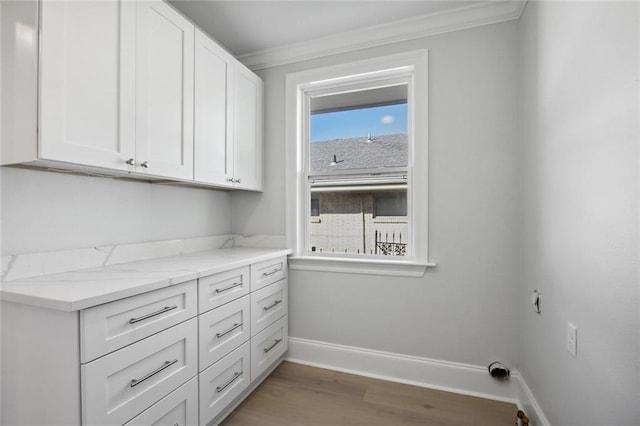 washroom with ornamental molding, cabinets, and hardwood / wood-style floors