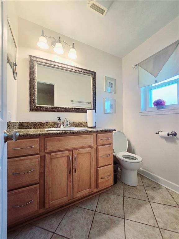 bathroom with tile patterned flooring, vanity, and toilet