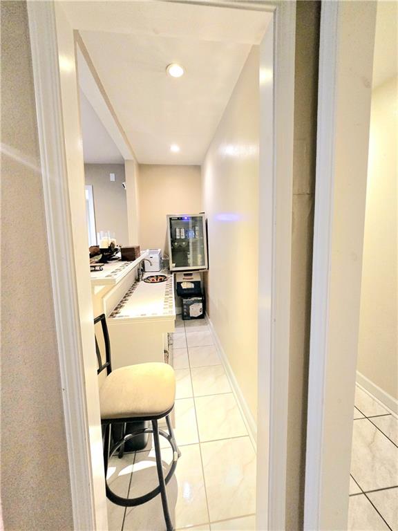 corridor featuring light tile patterned flooring and sink