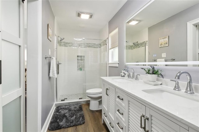 bathroom with toilet, vanity, an enclosed shower, and hardwood / wood-style flooring