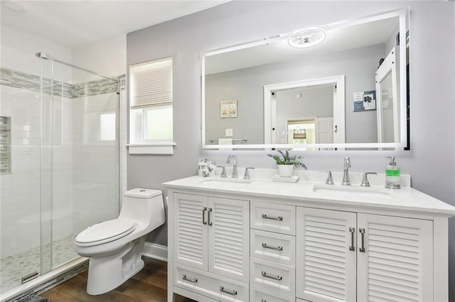 bathroom featuring wood-type flooring, vanity, toilet, and walk in shower