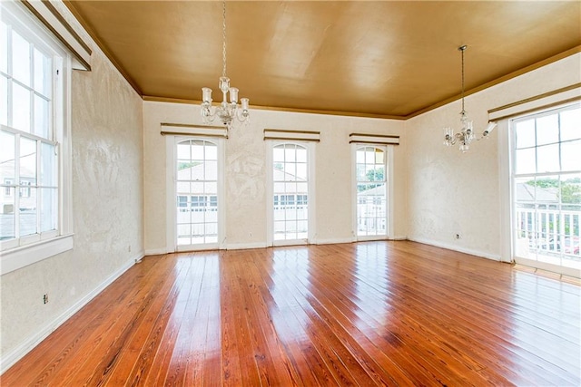 interior space with an inviting chandelier, hardwood / wood-style flooring, and crown molding