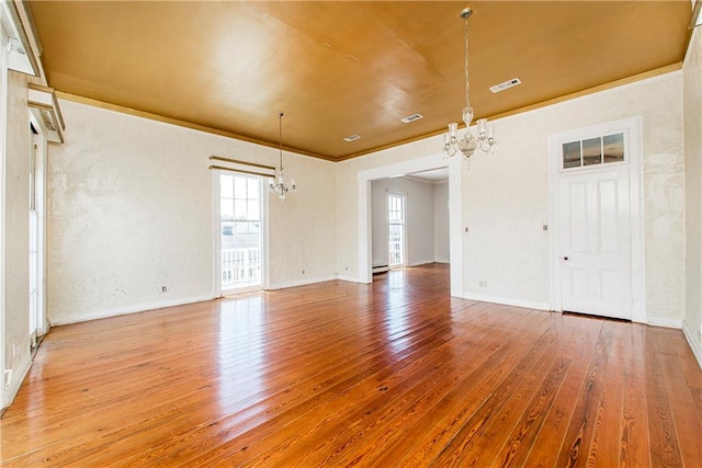 unfurnished room featuring hardwood / wood-style flooring and a chandelier