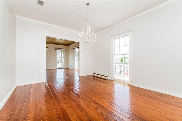 empty room with hardwood / wood-style flooring, a healthy amount of sunlight, crown molding, and an inviting chandelier