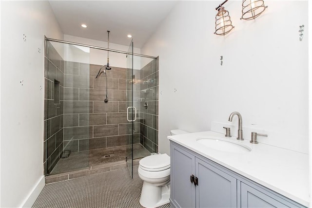 bathroom featuring toilet, vanity, tile patterned floors, and a shower with shower door