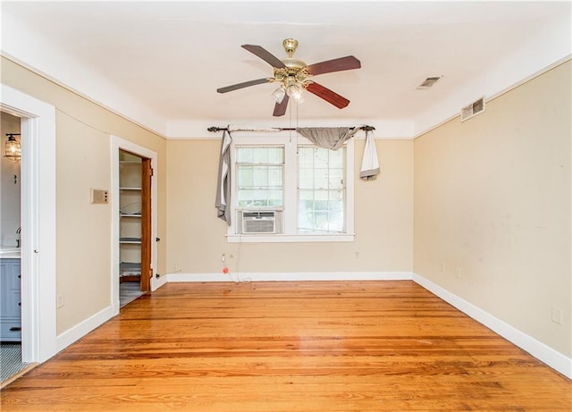 unfurnished room with light wood-type flooring, cooling unit, and ceiling fan