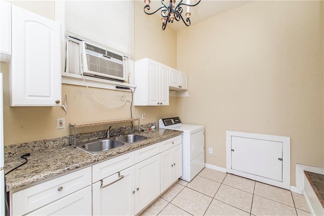 kitchen with an inviting chandelier, sink, light tile patterned flooring, white cabinetry, and washer / clothes dryer