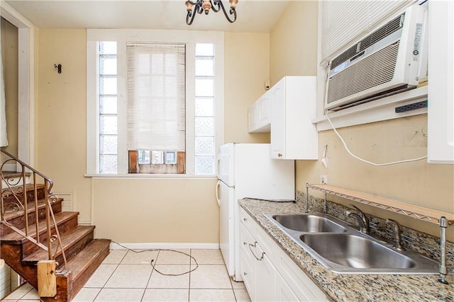 kitchen with white cabinets, plenty of natural light, light tile patterned floors, and white refrigerator