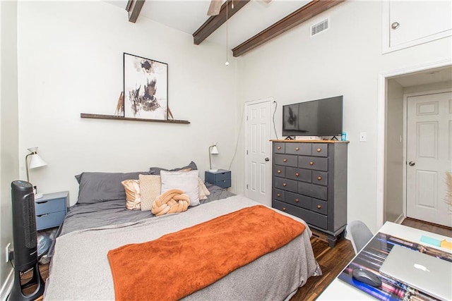 bedroom featuring dark wood-type flooring and beam ceiling