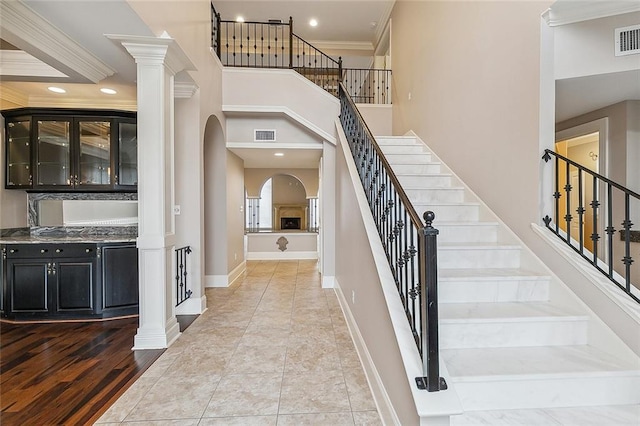 entryway featuring ornate columns, ornamental molding, and hardwood / wood-style flooring