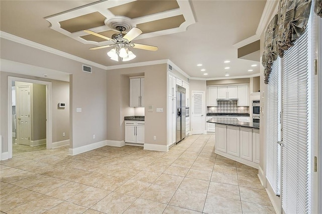 kitchen featuring tasteful backsplash, light tile patterned flooring, white cabinets, appliances with stainless steel finishes, and ceiling fan