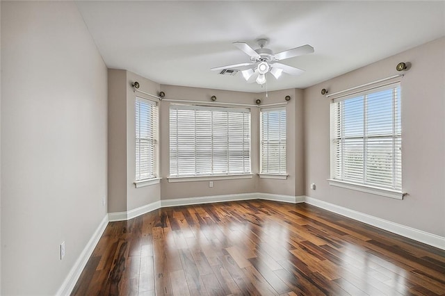 spare room featuring ceiling fan, plenty of natural light, and dark hardwood / wood-style floors