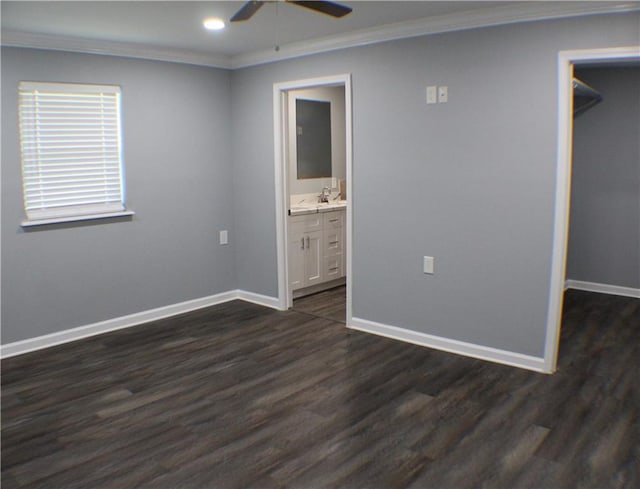 unfurnished bedroom with connected bathroom, ornamental molding, dark hardwood / wood-style flooring, and a walk in closet