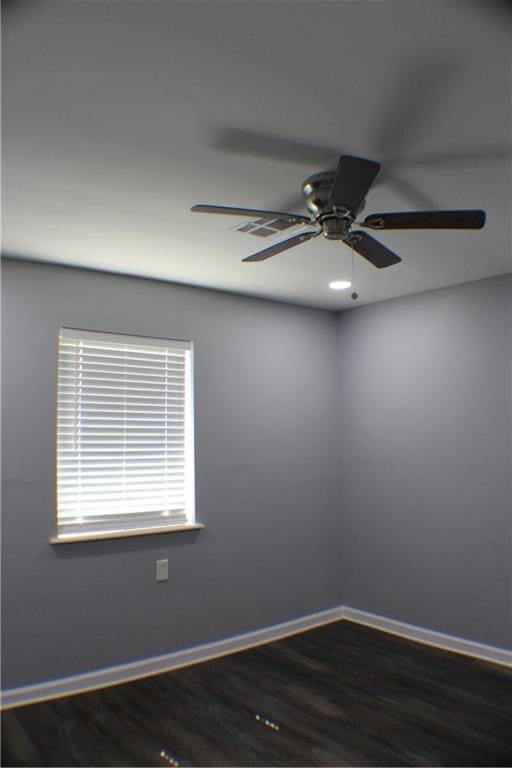 empty room with ceiling fan and dark wood-type flooring