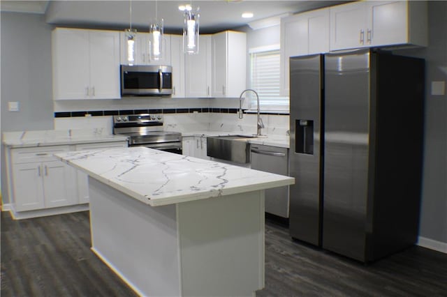 kitchen featuring white cabinets, a kitchen island, stainless steel appliances, decorative light fixtures, and dark hardwood / wood-style floors