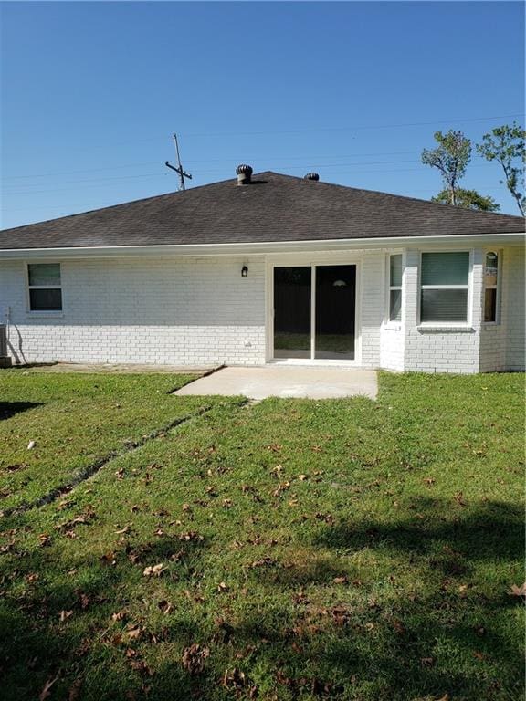 rear view of property with a yard, central air condition unit, and a patio area