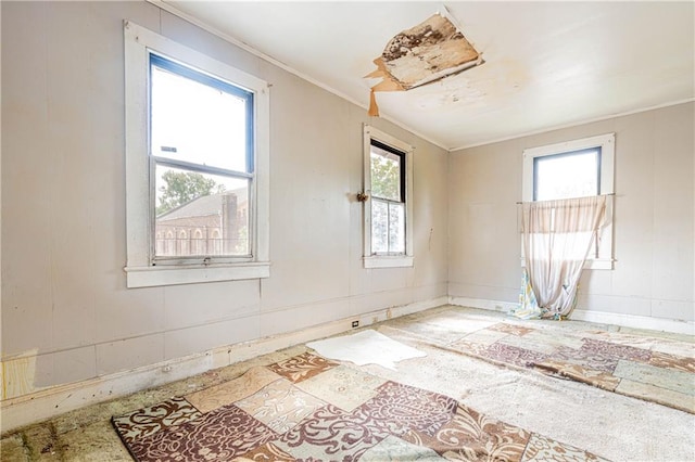 empty room featuring crown molding