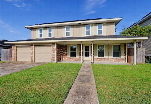 view of front of house featuring a front lawn, a garage, and covered porch