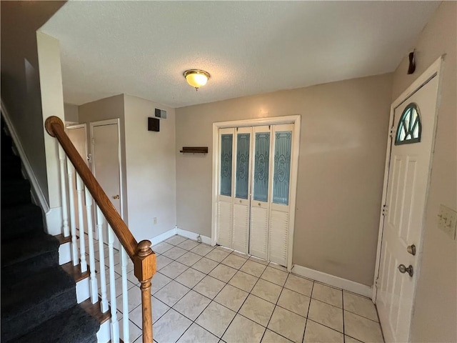 tiled entryway with a textured ceiling