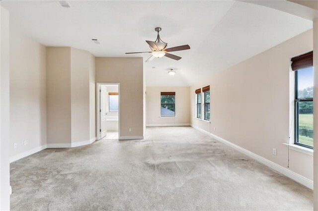 unfurnished room with light carpet, vaulted ceiling, a wealth of natural light, and ceiling fan