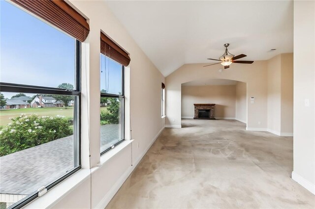 unfurnished living room with ceiling fan, carpet, and vaulted ceiling