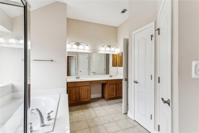 bathroom featuring tile patterned flooring, vanity, and a bathing tub