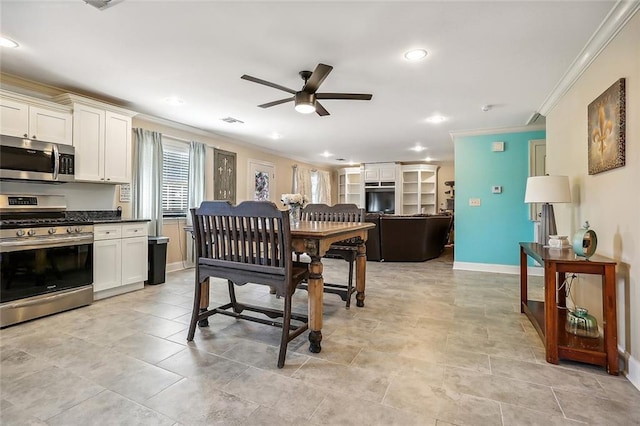 kitchen with crown molding, stainless steel appliances, light tile patterned flooring, ceiling fan, and white cabinets