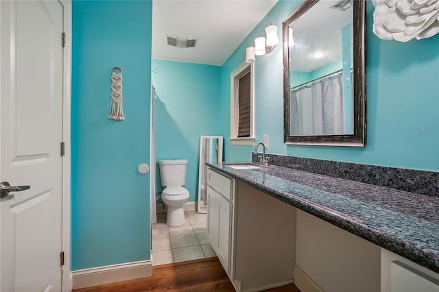 bathroom featuring vanity, toilet, and hardwood / wood-style flooring