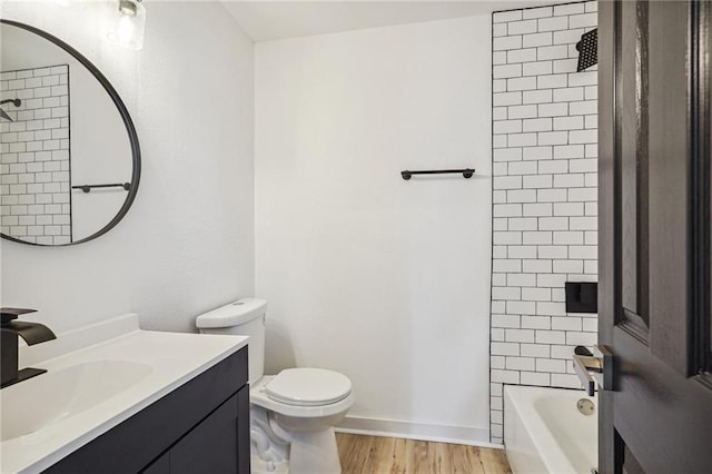 full bathroom with toilet, hardwood / wood-style flooring, tiled shower / bath combo, and vanity