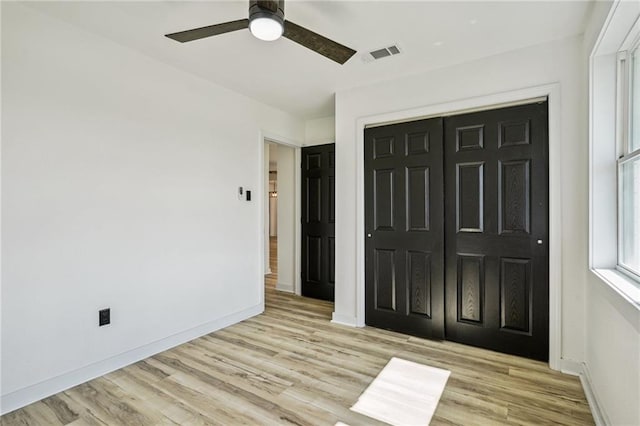 unfurnished bedroom with light hardwood / wood-style flooring, ceiling fan, and a closet