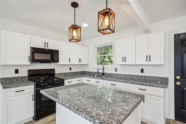 kitchen with black appliances, sink, a center island, and white cabinets