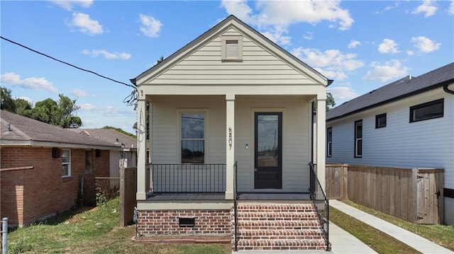 rear view of property with fence and covered porch